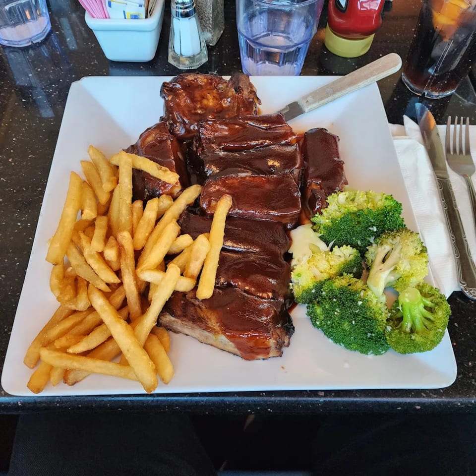 A plate of BBQ ribs with french fries and steamed broccoli at Parkview Diner.